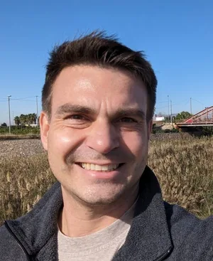 Steven Machamer, smiling, outdoors on a sunny day